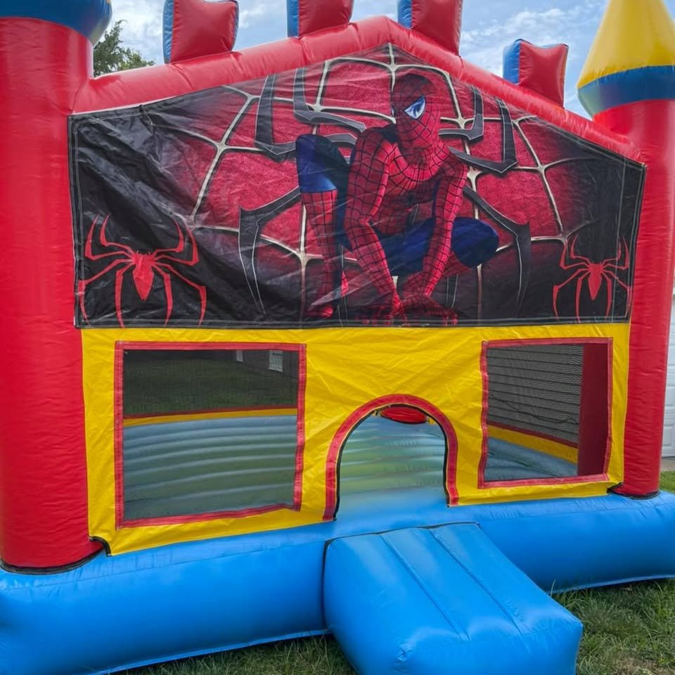 Red, blue, and yellow Spider-Man bounce castle with mesh windows on grass